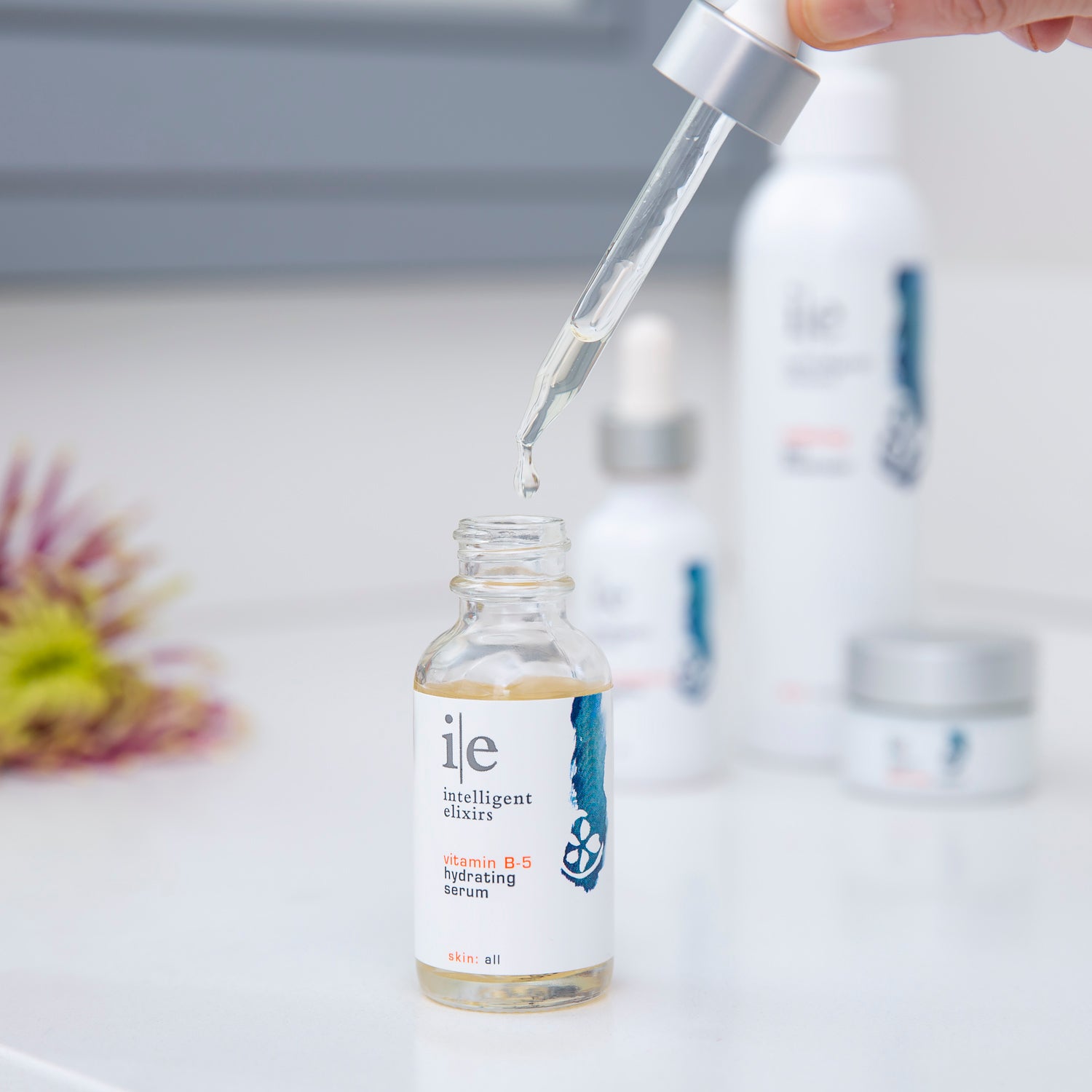 Vitamin B-5 Hydrating Facial Serum with hand holding the applicator dropper over the bottle